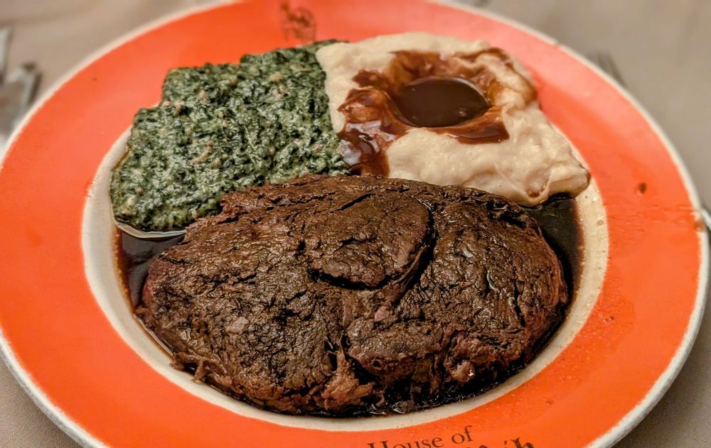A thick city cut of prime rib with mashed potatoes and creamed spinach